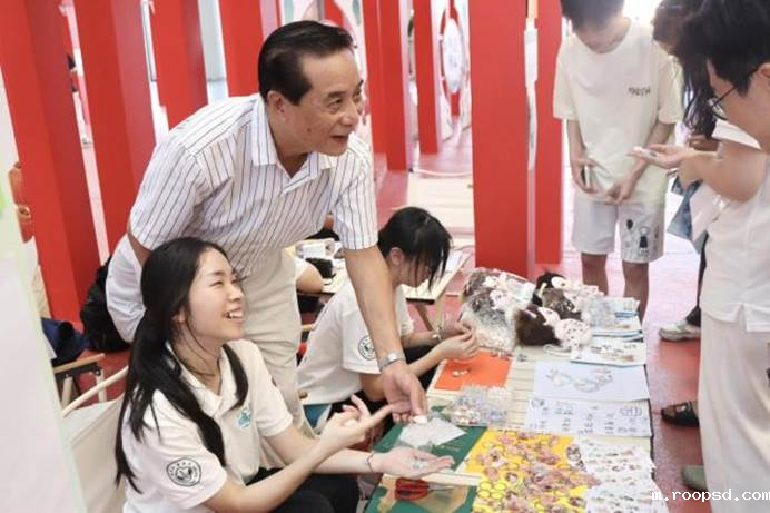 汕头贝雕传承人林汉桂先生指导队员摆摊售卖贝雕文创产品